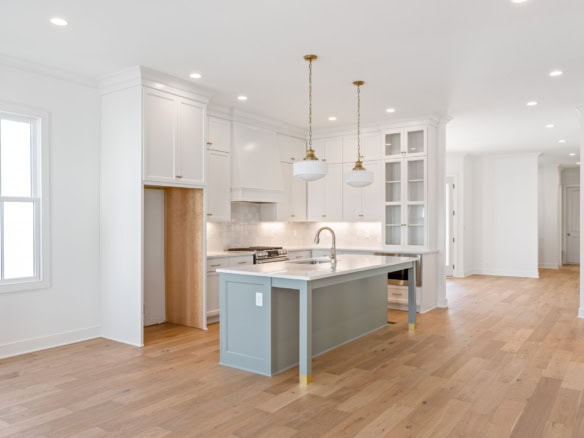 Bright, open-concept kitchen with white cabinetry and hardwood floors.