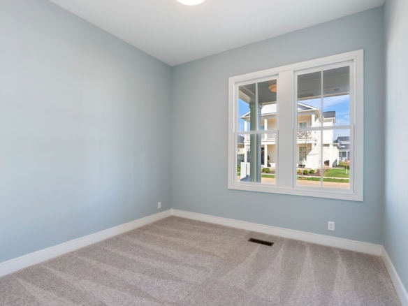 Bright empty room with large window and neutral walls.