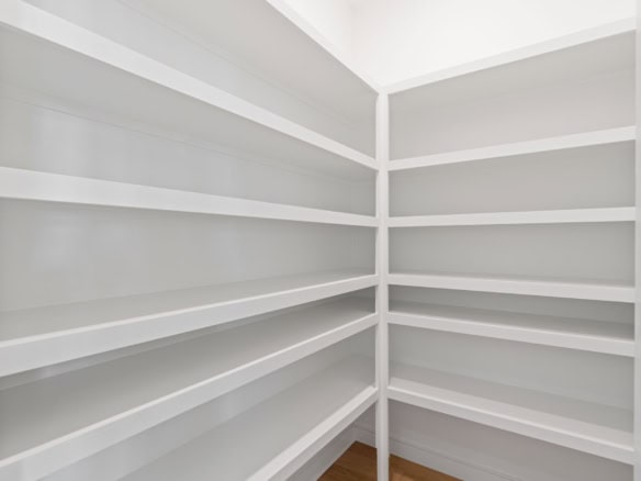 Custom white built-in shelves in a corner for storage.