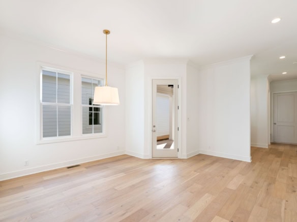 Bright, spacious living room with white walls and hardwood floors.