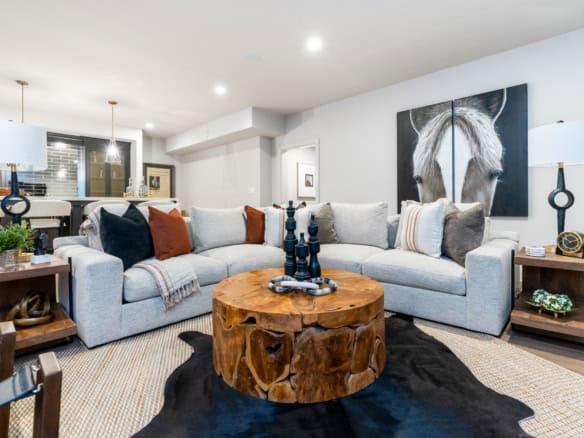 Contemporary living room featuring a horse painting, cozy sofa, and wooden coffee table.