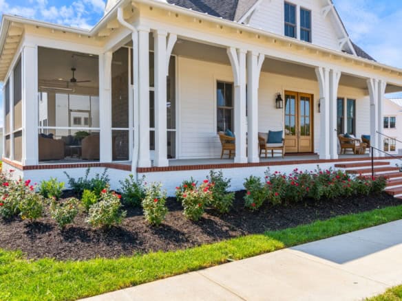 Beautiful front porch of a modern craftsman home with white trim and blue accents.