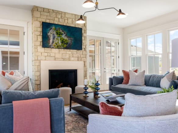 Bright, inviting living room featuring a cozy fireplace, large windows, and stylish furniture.