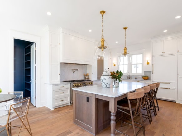 Bright, modern kitchen with white cabinets, island, and pendant lighting.
