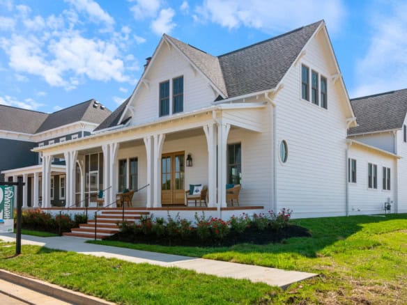 Beautiful white house with a spacious front porch and well-maintained lawn.