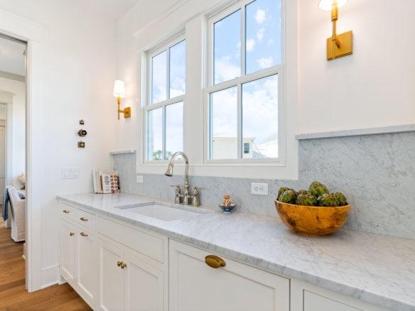 Bright kitchen featuring large windows and elegant marble countertops.