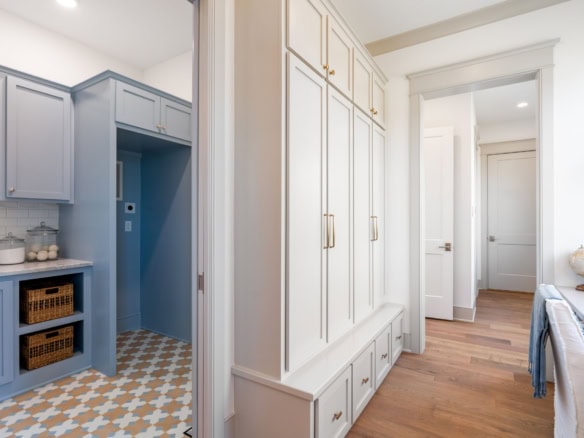 Bright kitchen featuring blue cabinets, white walls, and hardwood floors.