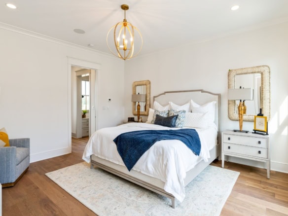 Bright bedroom with white walls, stylish furniture, and natural light.