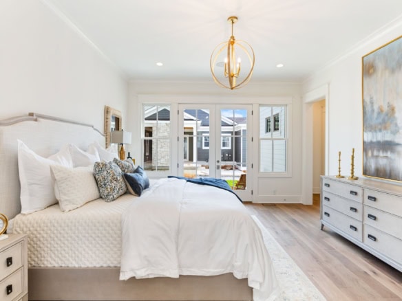 Bright, modern bedroom with large windows, white furniture, and stylish decor.