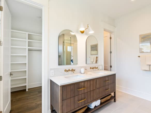 Bathroom with double sink vanity and walk-in closet in a new home.