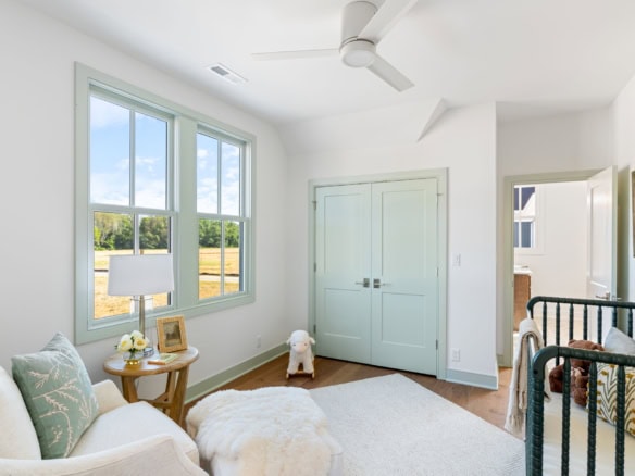 Bright bedroom featuring large windows, white walls, and cozy decor.