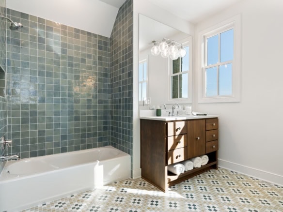 Bright bathroom featuring a bathtub, vanity, and large windows at 11530 River Beauty Loop.