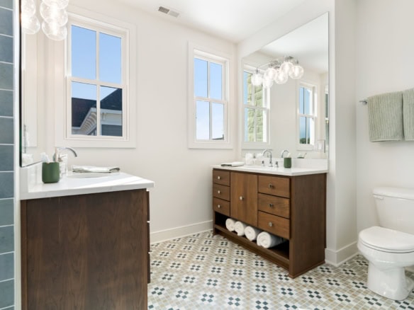 Bright and spacious bathroom with double vanities and stylish tile flooring.