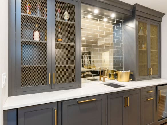 Modern kitchen cabinetry with glass-front upper cabinets and gold hardware for stylish home design.