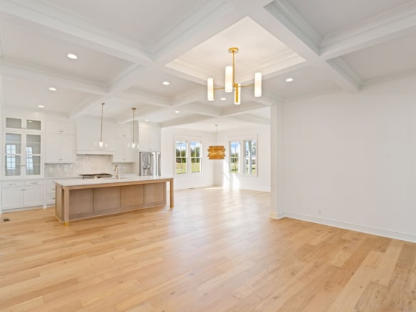 Bright, spacious open-concept kitchen and living room with hardwood floors.