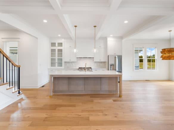 Bright, spacious kitchen with white cabinets and hardwood floors.