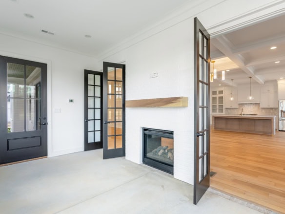 Bright living room with fireplace and view of open kitchen.