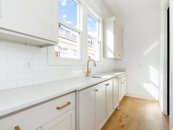 Bright kitchen with white cabinets, subway tile backsplash, and natural light.