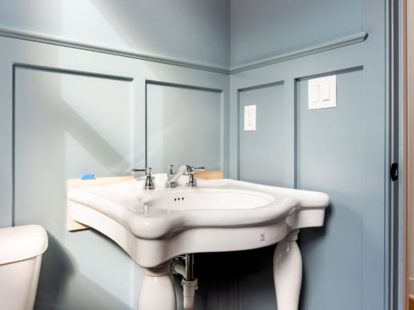 Modern bathroom with light blue walls and a white sink.