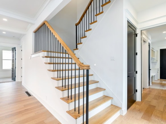 Bright interior staircase with wooden steps and black metal railing at 11612 Skypilot Street.
