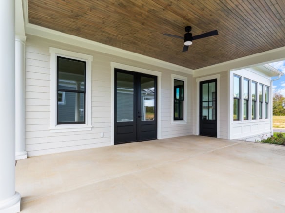 Porch with black doors, large windows, and ceiling fan at 11612 Skypilot Street.