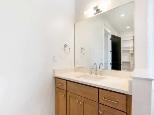 Bathroom vanity with wooden cabinets and mirror at 11612 Skypilot Street.