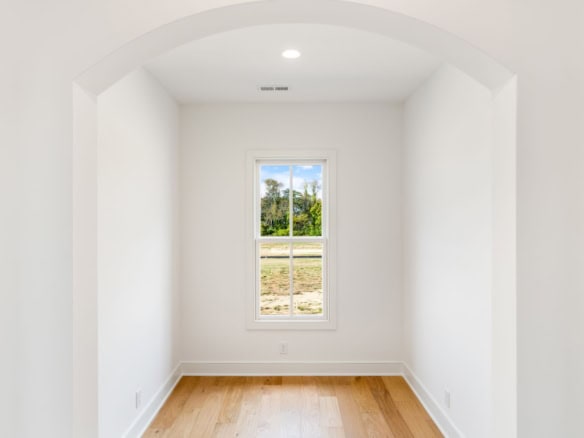 Bright white interior room with a window overlooking greenery.