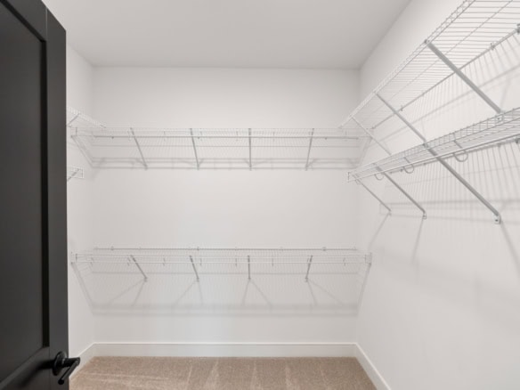 Spacious walk-in closet with wire shelving for organization.