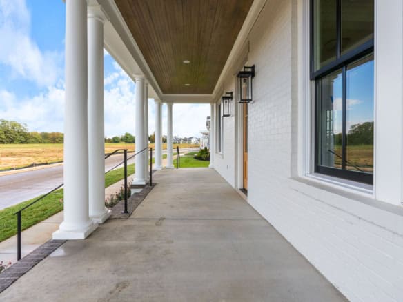 Porch with white brick walls, columns, and black lanterns at 11612 Skypilot Street.