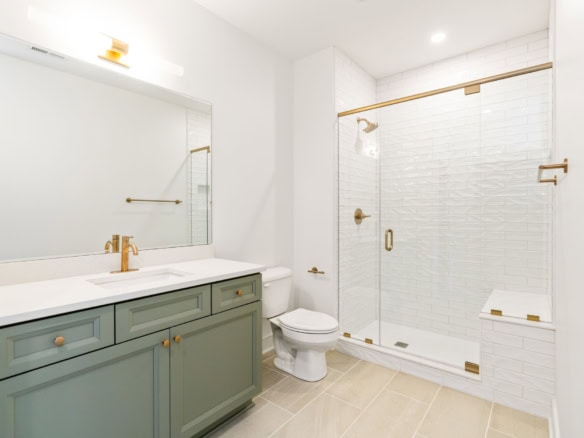 Bathroom with glass shower, white tiles, and green vanity for 11612 Skypilot Street.