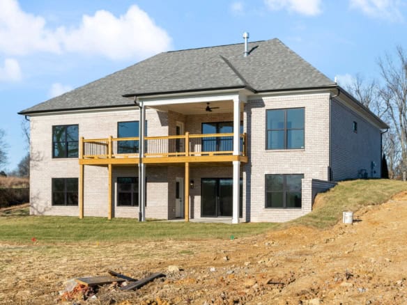 Beautiful new construction home with a spacious balcony and large windows.