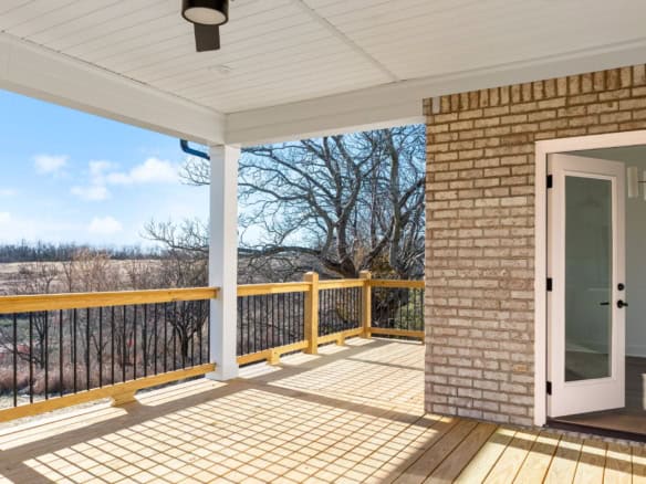 Balcony with wooden railing and brick wall at 3228 Catalpa Farms Drive, showcasing outdoor living sp.