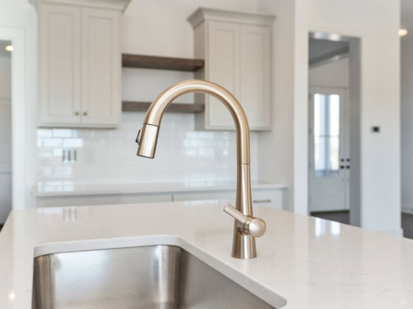Modern kitchen sink with stainless steel faucet in a bright, contemporary kitchen setting.