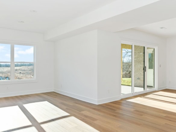 Bright, open living room with large windows and sliding glass door.
