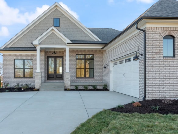 Beautiful new construction home with brick and siding exterior, spacious driveway, and attached gara.