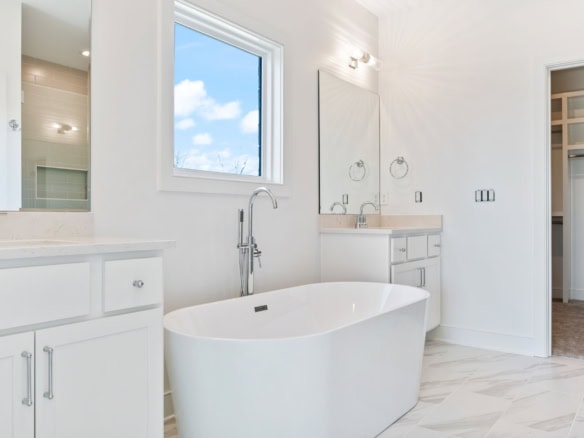 Elegant modern bathroom with freestanding tub and large window.