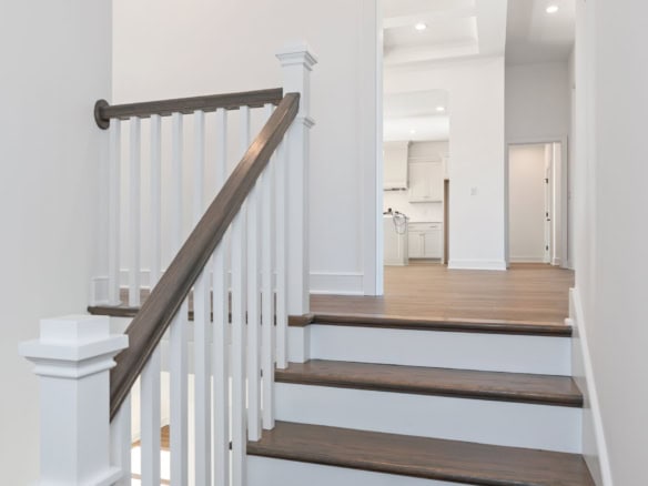 Staircase with dark wood steps and white railing in a modern home interior.