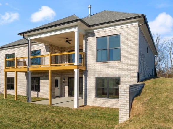 Modern brick home with balcony and large windows.