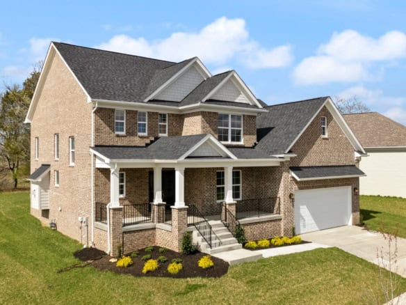 Beautiful brick-front house with spacious porch and well-maintained lawn.