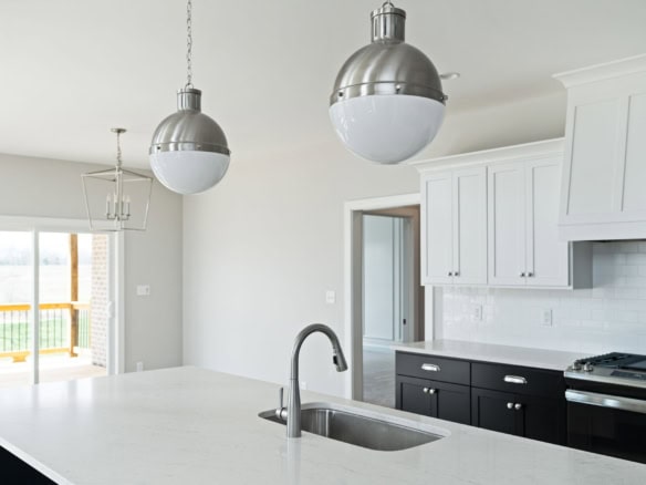 Elegant kitchen with white cabinets and stainless steel appliances.