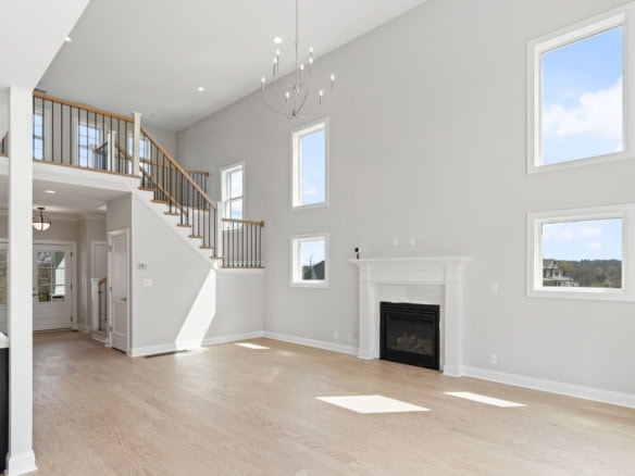 Spacious living area featuring a fireplace, large windows, and high ceilings, showcasing quality con.