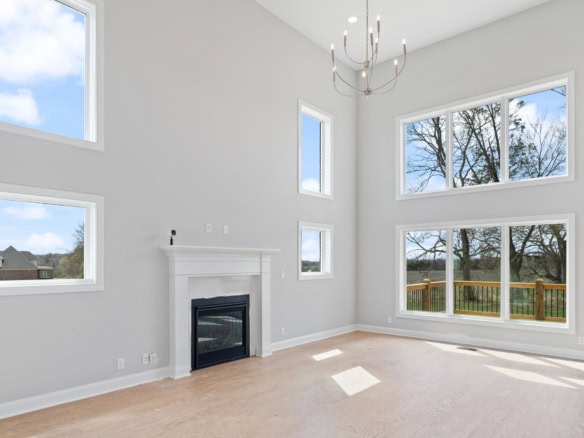 Bright living room featuring expansive windows and a cozy fireplace, perfect for relaxing and enjoyi.