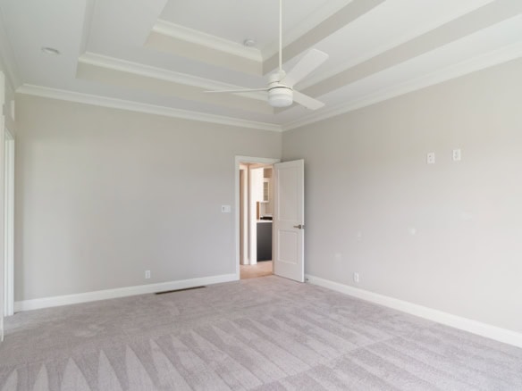 Bright, spacious bedroom with neutral walls and plush carpet flooring.
