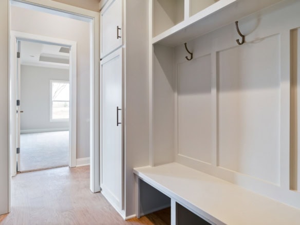 Modern mudroom with built-in storage, hooks, and bench for organization.