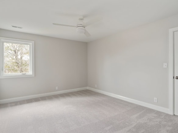 Interior of a newly built home with light gray walls and carpeted flooring.