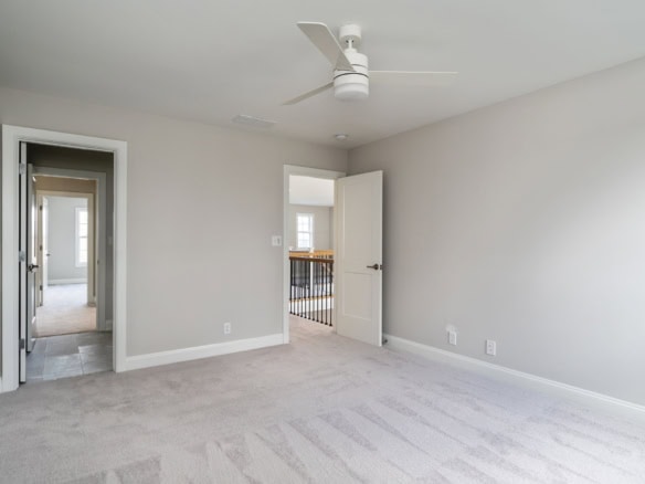 Bright, spacious interior with neutral walls and plush carpet in a newly built home.
