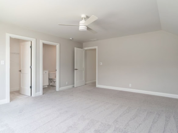 Interior living room with neutral walls, ceiling fan, and spacious layout.