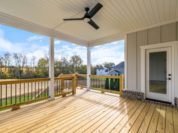 Covered porch with ceiling fan and wooden railing at 3235 Catalpa Farms Dr.