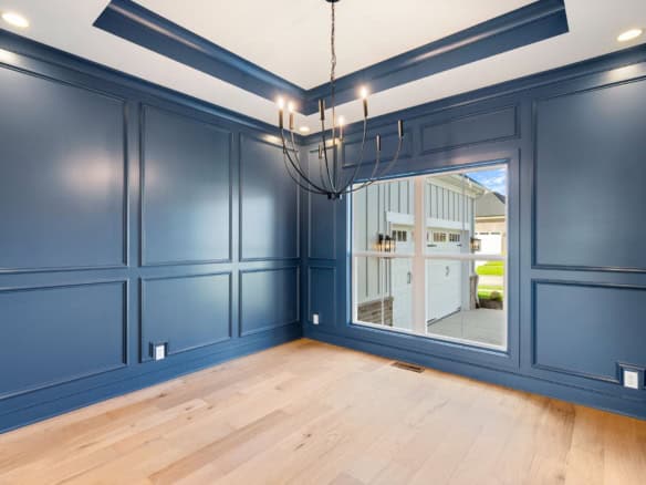 Blue wall paneling with decorative molding in a new home.
