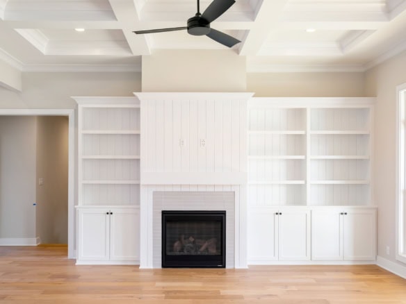Built-in white shelves and fireplace in a spacious living room.